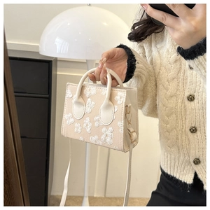 Detail of cream square handbag with 3D floral lace embroidery and dual handles