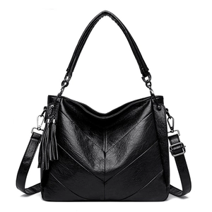 Detailed view of black litchi textured leather tote with V-quilt pattern and tassels