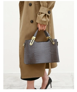 Close-up of crocodile embossed leather handbag with premium gold metal hardware detail