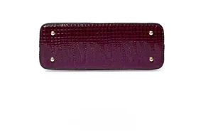 Detail shot of purple crocodile pattern handbag base with protective gold metal feet