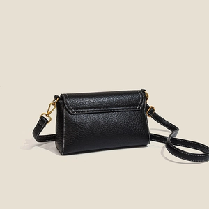 Retro black leather crossbody bag with chain and gold hardware from a side-angle view
