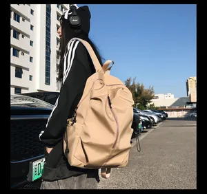 Close-up of a beige high-capacity backpack featuring vertical zipper pockets and durable nylon
