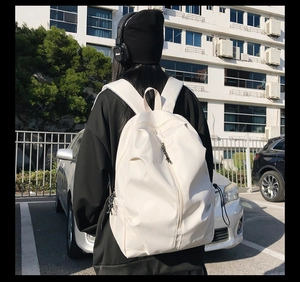 Detail of white water-resistant backpack with vertical pleats and side drawstring buckle