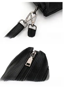 Détail des crochets en métal gris fusil et de la fermeture éclair sur sac noir en cuir