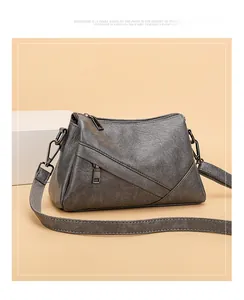 Détail du sac bandoulière gris foncé avec texture grainée et fermeture éclair latérale