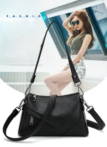 Détail du sac bandoulière en cuir grainé noir avec coutures asymétriques et zips métalliques