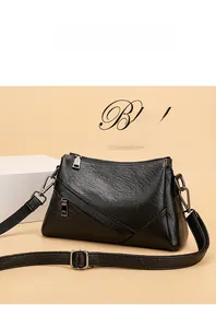 Détail d'un sac bandoulière noir en similicuir texturé avec sangle et boucles en métal