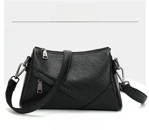 Détail du sac bandoulière en cuir grainé noir avec fermetures éclair argentées