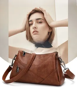 Détail du sac bandoulière marron vintage avec bandoulière réglable et ferrures en métal