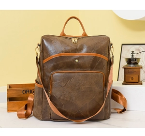Detailed view of vintage patchwork backpack showing leather texture and golden zippers