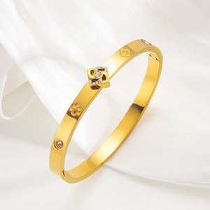Polished 18k gold plated titanium steel bangle with clover pattern and cubic zirconia