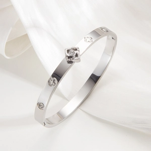 Polished silver stainless steel clover bracelet with sparkling zircons on white silk