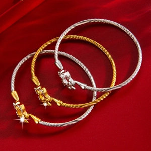 Détail de trois bracelets torsadés avec cristaux sur fond en cuir rouge élégant