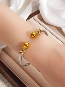 Macro detail of two-tone cable twisted cuff bracelet with sparkling crystal accents