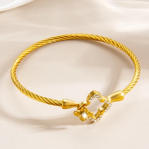 Détail du bracelet trèfle doré avec texture torsadée et zircons étincelants