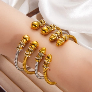 Set of four twisted steel cable cuff bracelets in gold and silver with crystal accents