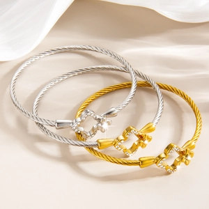 Ensemble de trois bracelets câble en acier trèfle avec finitions or 18 carats et argent