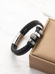 Detail of black woven leather bracelet with silver magnetic clasp and embossed metal sliders