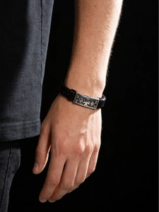Close-up of woven leather bracelet with cross pattern buckle on male model's wrist