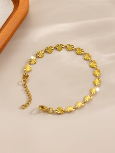 Close-up of golden heart links with radial engravings on satin background