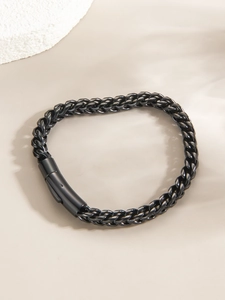 Détail d'un bracelet gourmette tressé noir mat avec fermoir cylindrique moderne pour homme