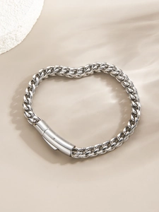 Vue macro d'un bracelet gourmette punk argenté avec détail de fermoir cylindrique