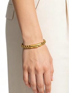Gros plan du bracelet chaîne épi dorée avec fermoir cylindrique au poignet d'un homme
