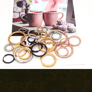 Various sizes and colors of round stainless steel hoop earrings in a minimalist style