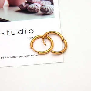 Polished gold round hoop earrings displayed on a minimalist white studio card backdrop