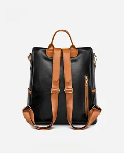 Detail view of the backpack back with black Oxford fabric and brown leather straps
