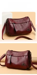 Détail du sac bandoulière marron rouge avec logo métallique et texture en cuir premium