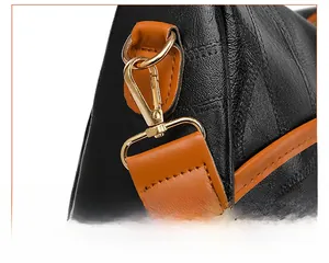 Detail of black pebbled leather texture with a detachable caramel shoulder strap