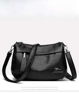 Gros plan du sac bandoulière noir avec texture litchi et logo métallique