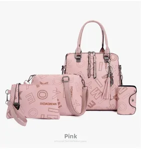 Detail of pink 4-piece handbag set featuring printed tote, crossbody and tassel charm