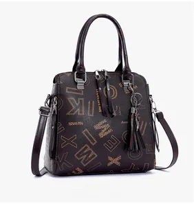 Detail view of large printed tote bag with metal tassels and textured leather finish