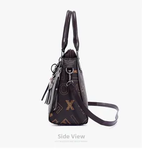 Side view of dark brown tote bag with yellow letters and tassel ornament detail