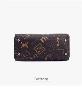Detail view of large handbag bottom featuring protective metal studs and printed texture