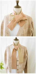 Detail of pink and beige striped knit scarf showing textured pattern and knotting style