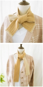 Detail of ginger knit scarf with white polka dots paired with houndstooth cardigan