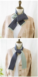 Detail of color-block knit scarf in navy and mint green with white polka dot patterns