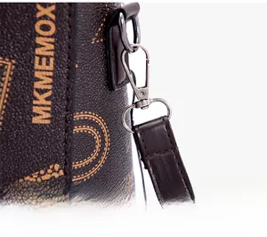 Detail of silver metal hook and strap connection on printed brown leather shoulder bag
