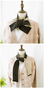 Close-up of black and white striped knit scarf showing dotted texture and soft fabric