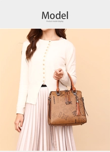 Brown leather tote bag with printed letters and tassel shown on model against neutral background
