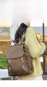 Outdoor lifestyle view of a vintage dark brown leather backpack with metal zippers