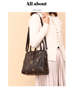 Brown vintage monogram tote bag with tassel charm styled on a model in knitwear