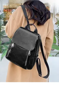 Detail of black soft leather backpack featuring vertical zip pockets and stitched texture