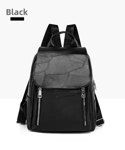 Detail of minimalist black faux leather backpack featuring textured patchwork and silver zippers