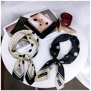 Mise à plat de plusieurs foulards en soie à pois de différentes couleurs sur la table