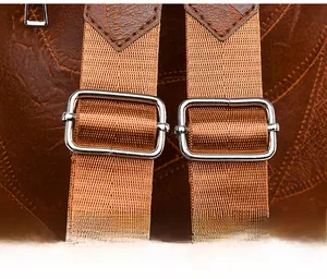 Detail of adjustable brown nylon shoulder straps with silver buckles on soft leather backpack