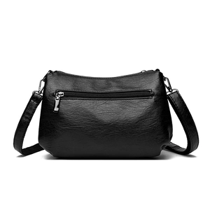 Sac bandoulière noir en cuir grainé avec poche zippée au dos et accessoires en argent